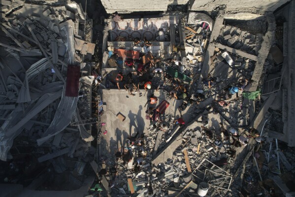 Palestinians inspect the rubble of buildings hit by an Israeli airstrike at Al Shati Refugee Camp Thursday, Oct. 12, 2023. As Israel escalates its war on Hamas, it will confront many of the same dilemmas it has grappled with over decades of conflict with the Palestinians. It will want to punish Hamas like never before, but without killing so many Palestinian civilians that it loses international support. (AP Photo/Hatem Moussa)